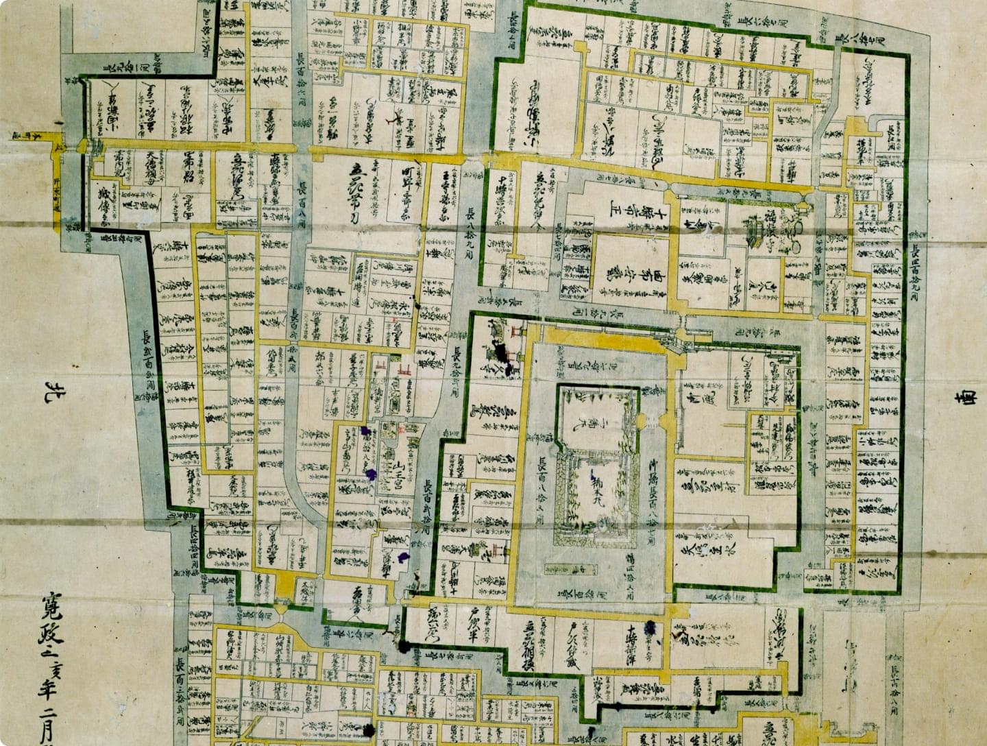 An old map of Yanagawa from the Edo period. A detailed city plan with streets divided into green and yellow lines and town and store names written in kanji.