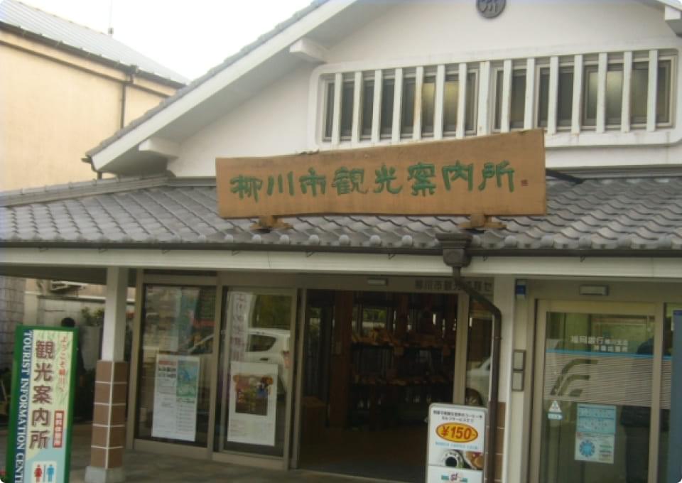 The exterior of Yanagawa City Tourist Information Center. A Japanese-style building with a wooden signboard.